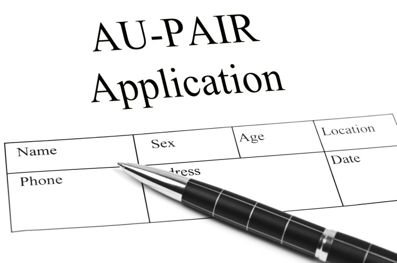 Black and white AU-PAIR Application form with fields for Name, Sex, Age, Location, Phone, Address, and Date, with a pen re...