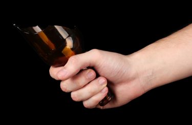 Can Bars and Restaurants Be Held Responsible for Alcohol-Related Fights? 1 Male hand with broken glass bottle