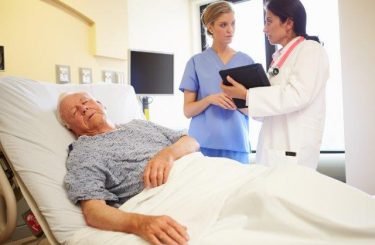 Patient in Hospital Bed Staff Discusssion