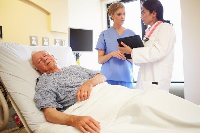 Patient in Hospital Bed Staff Discusssion