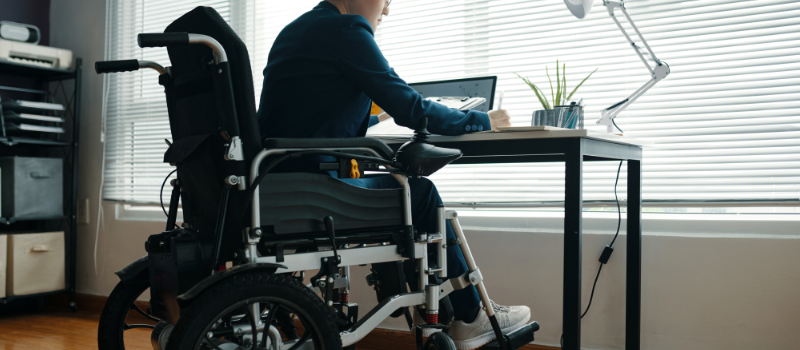 Person in wheelchair working at desk.