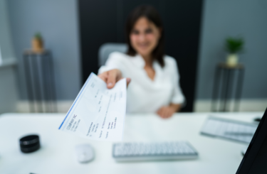 Female boss handing paycheck to employee