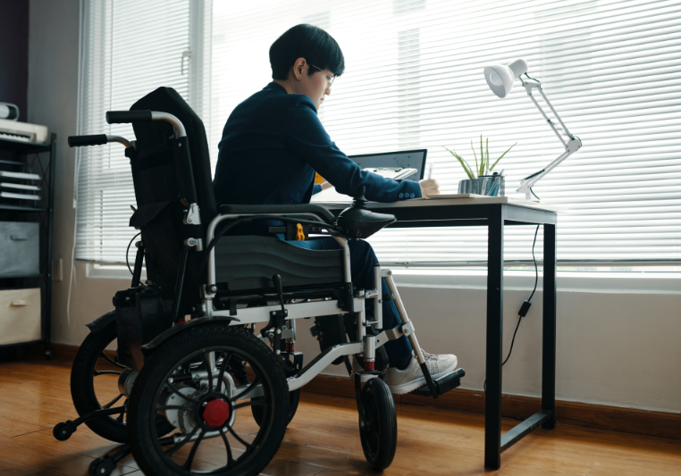 Person in wheelchair working at desk.